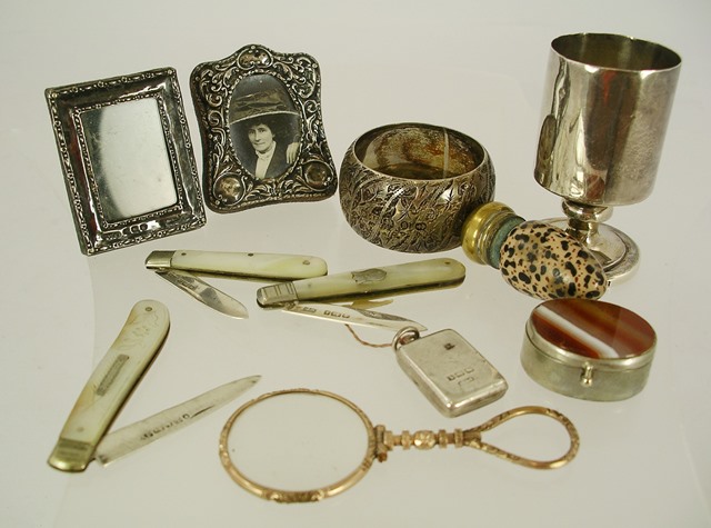 A SELECTION OF SILVER AND BASE METAL ITEMS OF VIRTUE, comprising a silver locket, a gilt metal