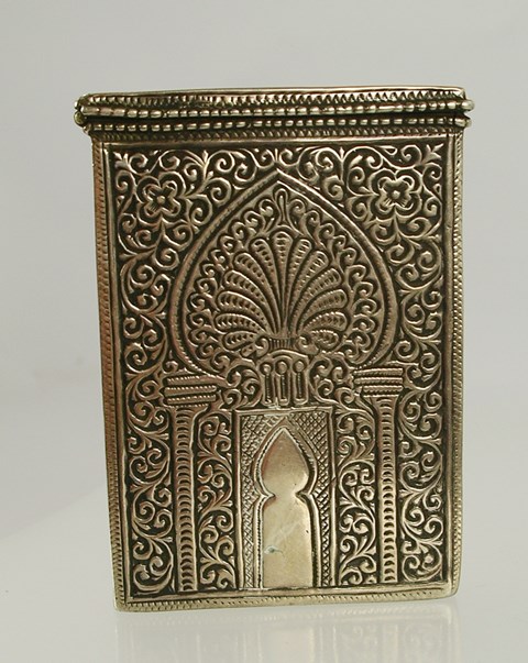 A FOREIGN SILVER COLOUR METAL ASIAN VISITING CARD CASE having hinged top all over richly tooled