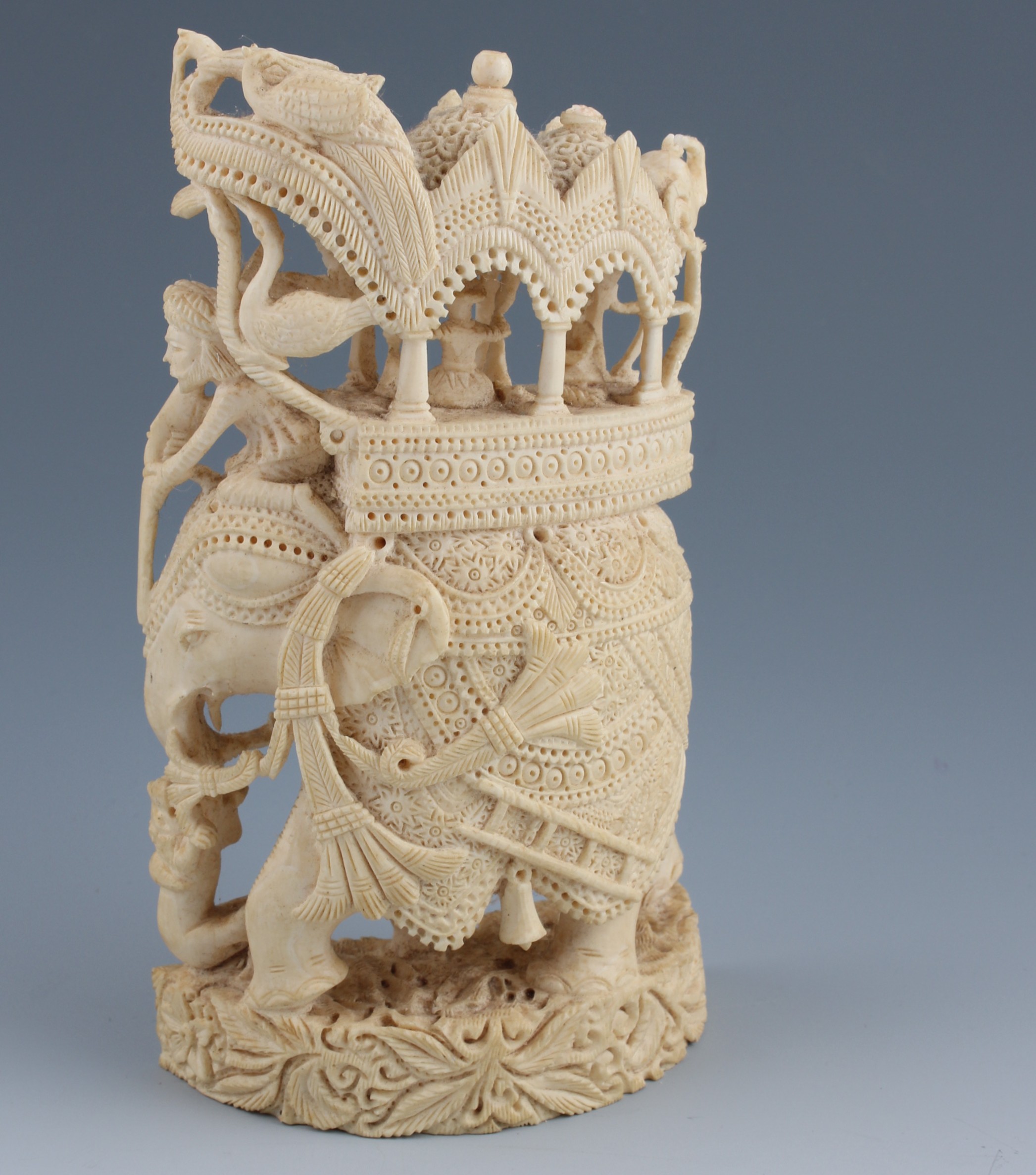 An early 20th Century Indian ivory carved and pierced group, the whole carved as an elephant and