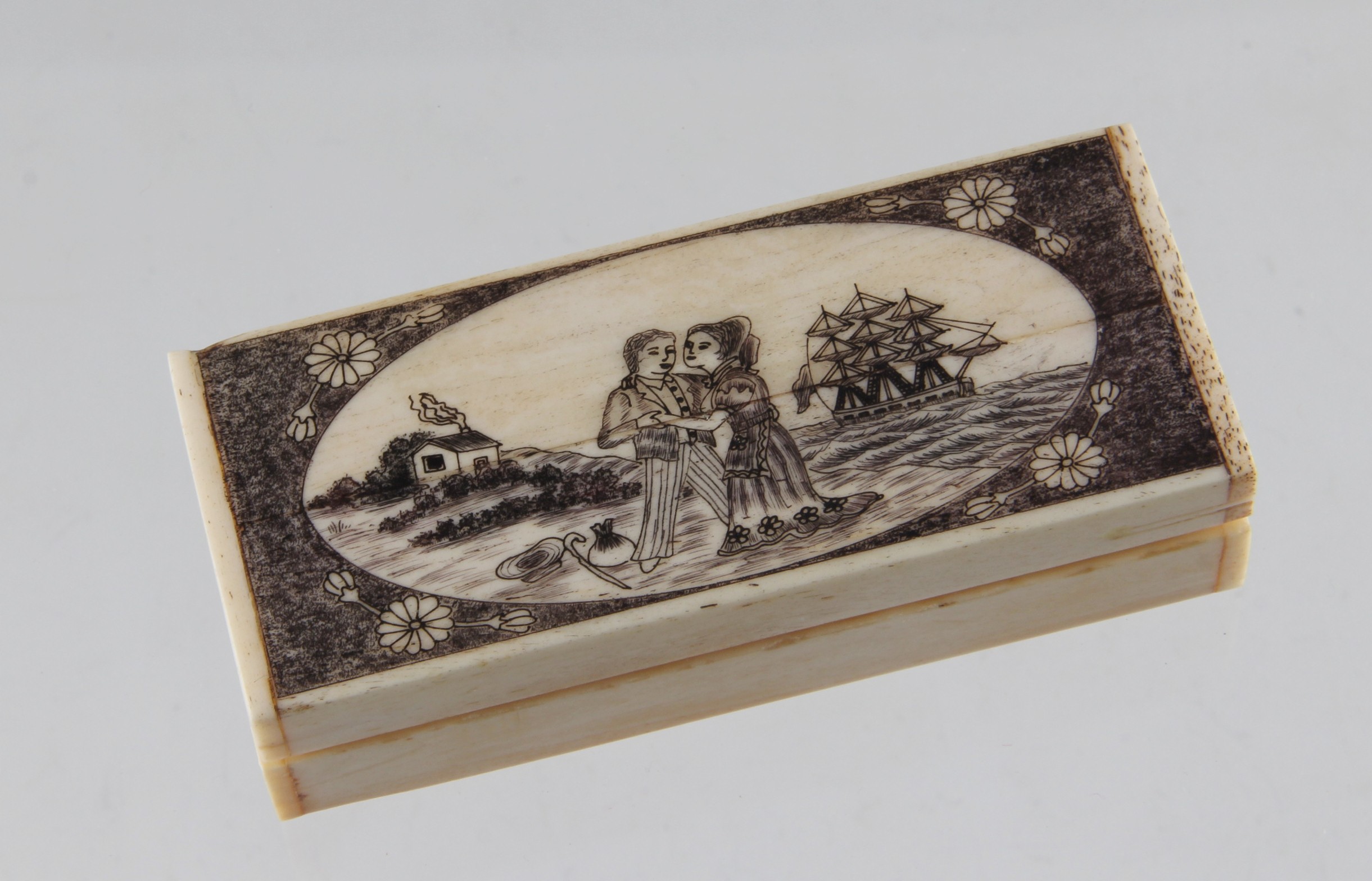 A reproduction bone scrimshaw style box, decorated with a sailor`s farewell, approx. 9.5 cm long.