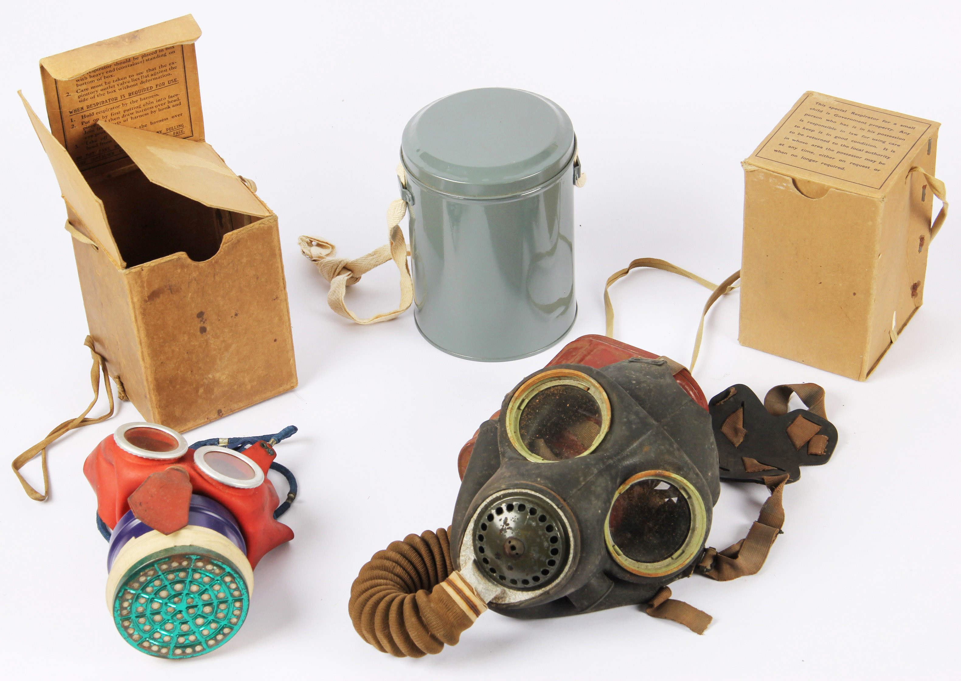 A group of four WW2 gas masks including a Mickey Mouse example with another childs gas mask, both