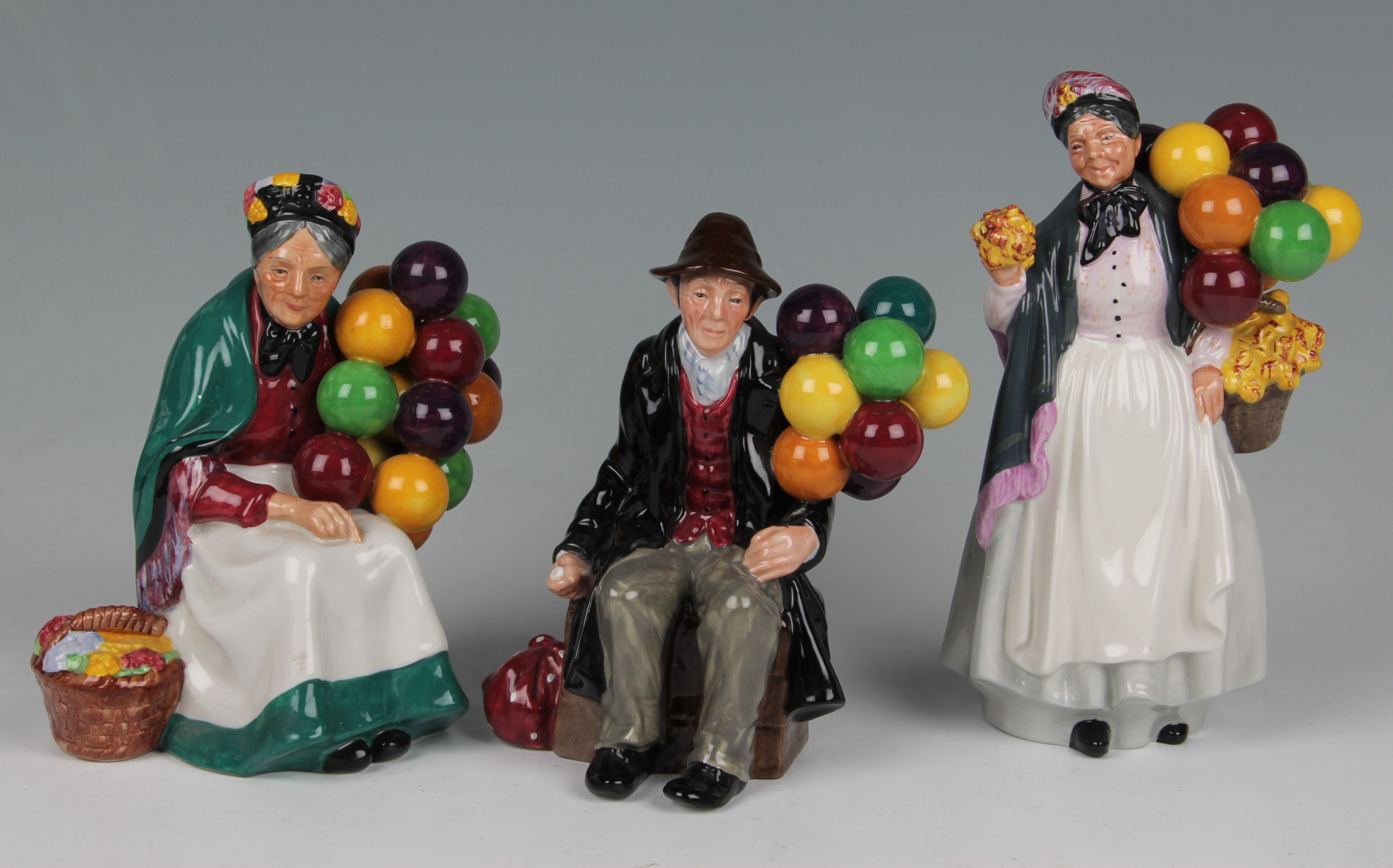 Three Royal Doulton figures, The old balloon seller HN 47941, The balloon man HN 1954 and Biddy