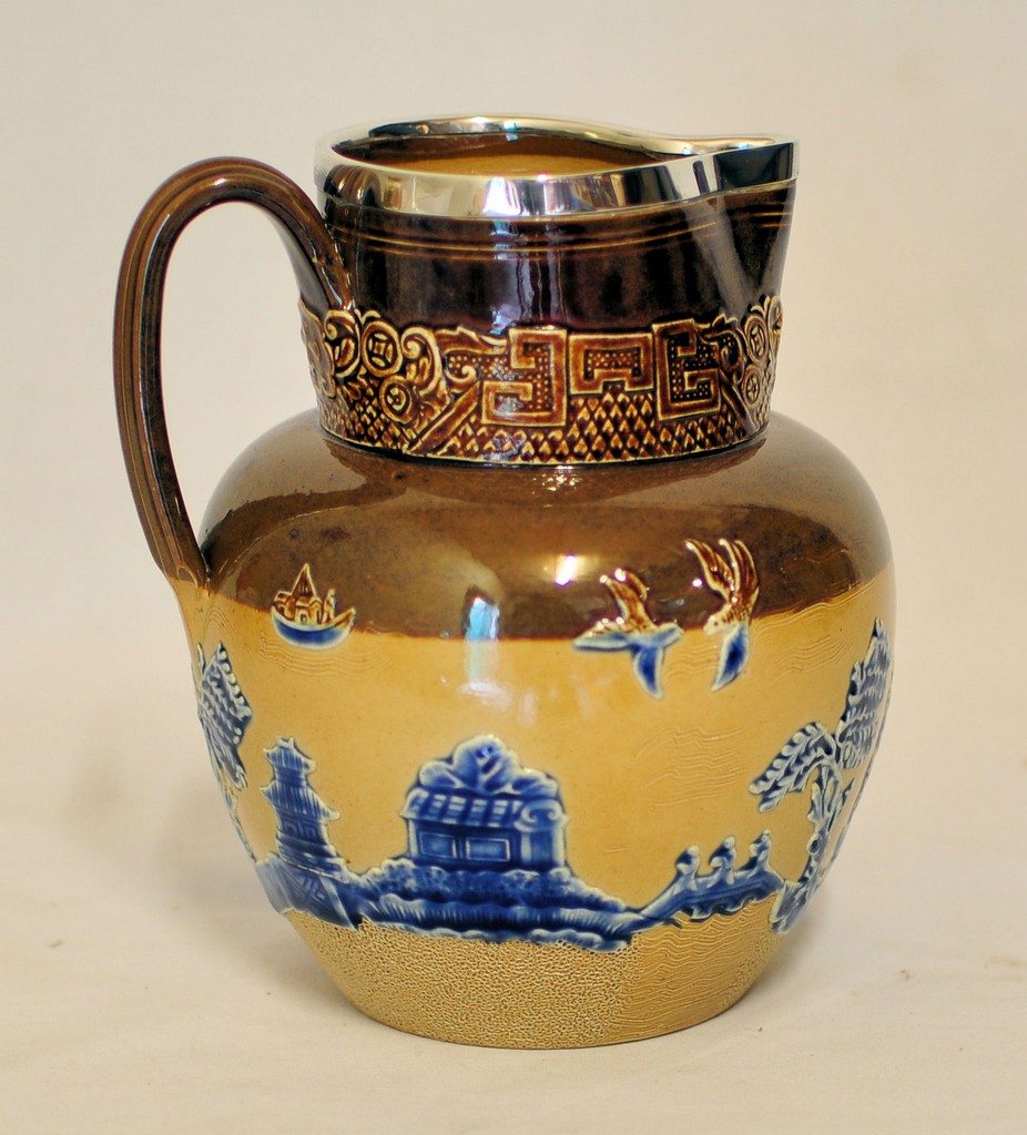 A late Victorian Doulton Lambeth stoneware Jug decorated with a raised willow pattern in blue and