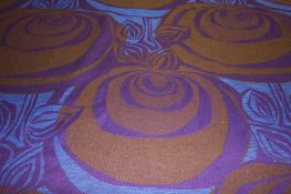 A roll of Edinburgh Weavers fabric `Orongo` pattern on a blue ground with purples and browns.