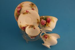 A Royal Worcester tea service decorated with roses by E S Pilsbury, comprising 6 cups and saucers, 6