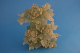 A carved 20th century jade vase and cover decorated with flowers and foliage. 30 cm high