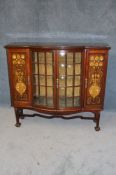 An Art Nouveau side cabinet by Shapland and Petter with two door glazed front flanked by two
