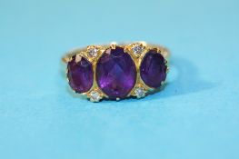 An 18ct gold ring set with three amethyst and four diamonds.