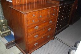 A 1920`s oak straight front chest of drawers with central panelled door flanked by 4 short