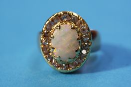 A gold ring set with large central opal and encased in diamonds, approx. 1.3cts.