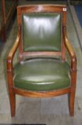 A mahogany open armchair with green leather back and curving seat having swept arms and supported on