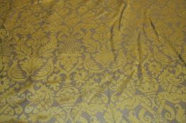 A large roll of fabric, satin finish, two tone gold decorated with birds and foliage. 30m plus