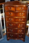 A reproduction Jenners mahogany serpentine front chest of drawers with two short and five long