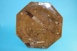 A Hopton Wood limestone octagonal charger with fossilized belemnites, ammonites etc. 40 cm diameter