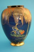 A Carlton Ware baluster shaped vase on a blue ground decorated with two storks beneath a flowering