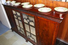 A mahogany dwarf bookcase with moulded cornice and blind fretwork below two glazed doors flanked