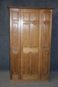 A late 19th century hall wardrobe with panelled door, moulded cornice, supported on a plinth base.