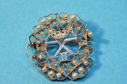 A white gold filigree style brooch, set with seed pearls and diamonds.