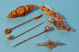 Four various 9ct gold brooches and three gold tie pins.