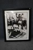 A large framed photograph signed by Muhammad Ali. The photograph showing Ali standing over the
