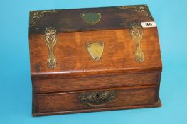 A Victorian oak and brass bound stationery box, with pull out drawer and rising sloping lid. 31 cm