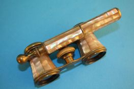 A pair of mother of pearl opera glasses with swing handle.