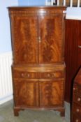 A reproduction mahogany serpentine fronted cocktail cabinet supported on bracket feet. 71 cm wide