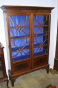 An early 20th century mahogany china cabinet with moulded and dentil cornice below two glazed