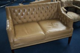 A Chesterfield high back two seater settee in caramel and a matching armchair.