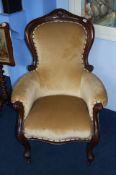 A Victorian mahogany armchair with shaped back, scrolled arms and serpentine seat supported on