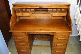 A 1930`s tambour fronted desk opening to reveal a fitted interior, each pedestal with three