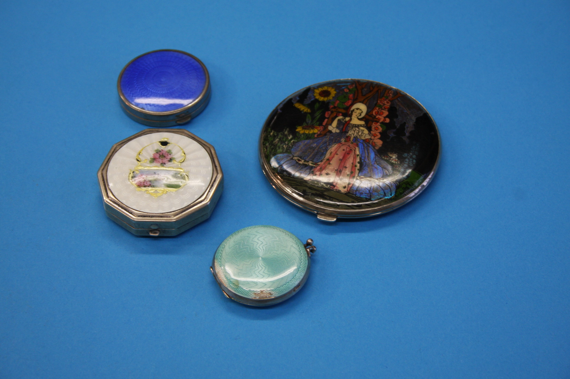 A circular silver and green enamelled compact; a sterling silver octagonal enamelled compact and 2