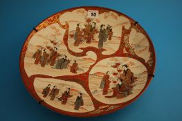 An early 20th century Japanese Kutani wall plaque decorated with panels of figures, bears