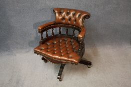 A reproduction leather captain`s office chair in brown leather.