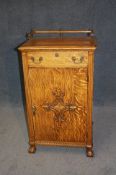 A 20th century oak food/drinks cabinet, the top with railed gallery below a single drawer, below a