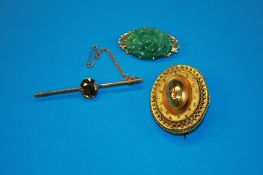 A Victorian 15ct gold oval brooch, weight 8.2 grams; an 18ct gold mounted jade brooch and a 15ct