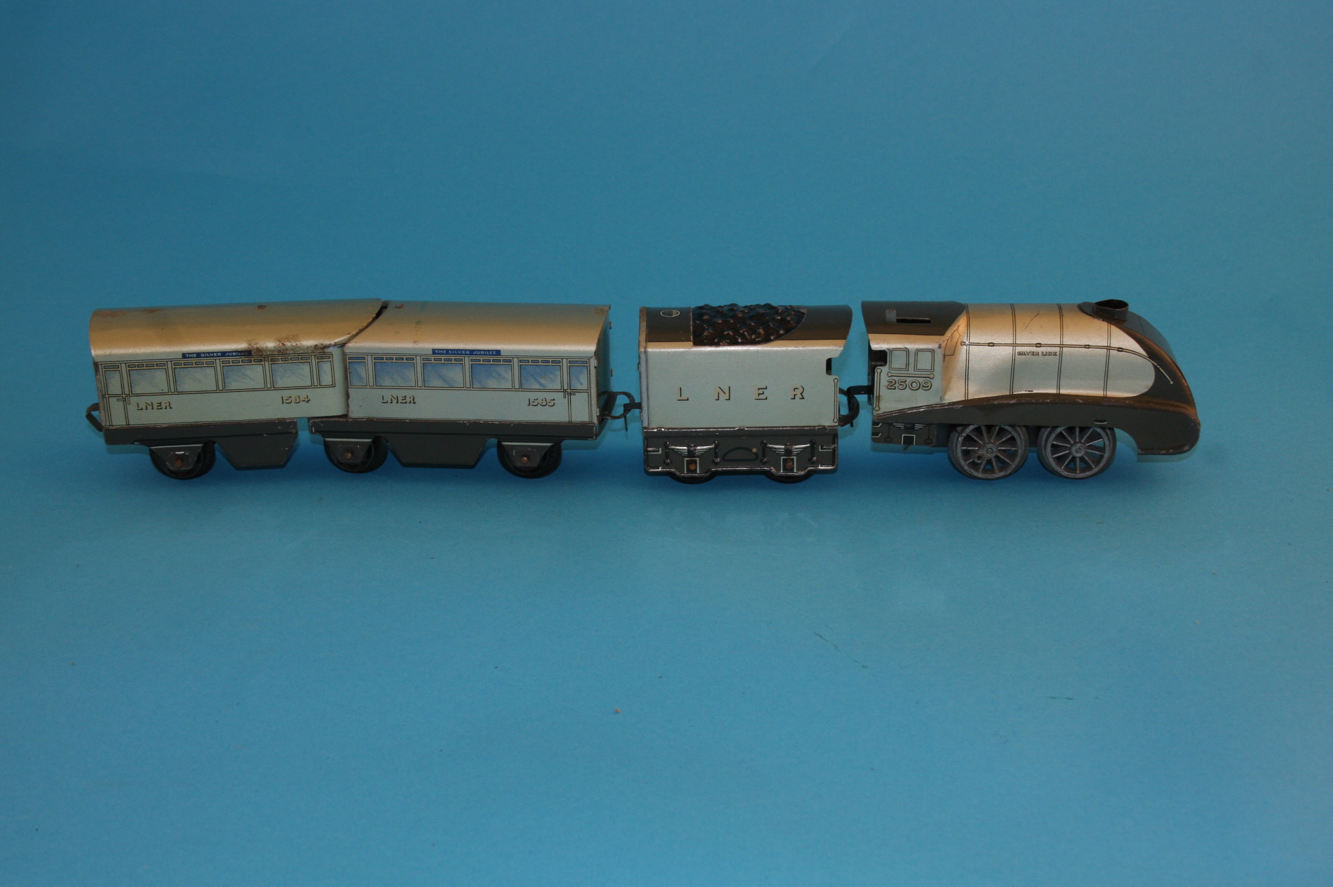 A Hornby "O" gauge clockwork Silverlink 0-4-0 locomotive, tender and two carriages LNER, a Hornby