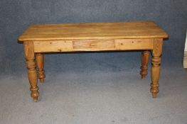 A pine farmhouse kitchen table supported on turned legs. 143 cm long