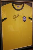 A framed Brazilian football shirt autographed by Pele, photograph verso.86 cm x 66 cm maximum