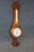 A small carved oak barometer. 65 cm high