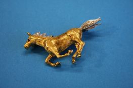 An 18ct gold horse with white gold and diamond mane and tail. Weight 12.8 grams