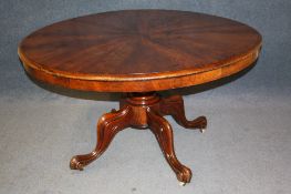 A Victorian mahogany circular tilt top dining table with segmented top, supported on a turned