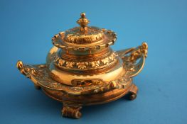 A Victorian ornate brass inkstand decorated with mythical beasts, supported on scrolled feet.14 cm