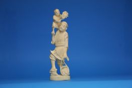 An early 20th century Japanese carved figure of a fisherman with a young boy on his shoulder. 18 cm