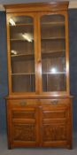 A tall late 19th century oak bookcase with moulded cornice, two arched glazed doors  below 2 short
