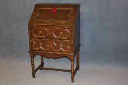 A small oak barley twist bureau with fall front, below two drawers supported on barley twist legs.