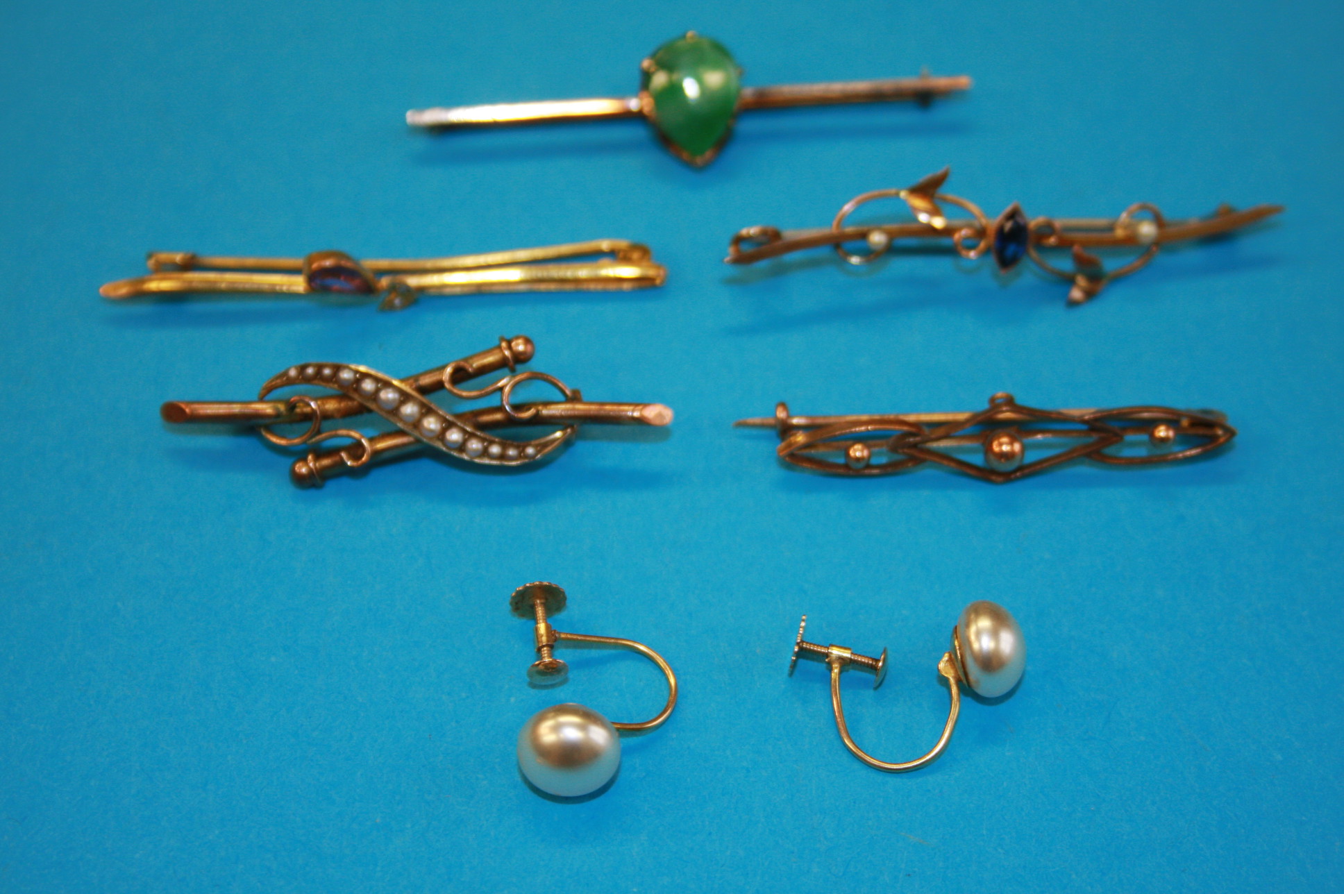 A 14ct gold bar brooch; 4 9ct gold bracelets and a pair of 9ct gold clip on earrings.