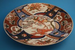 A late 19th century large Japanese Imari wall plaque decorated with panels of birds, trees and