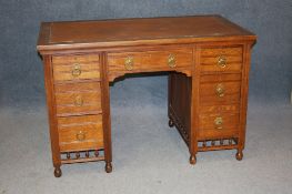A late Victorian oak pedestal desk with inset top below seven drawers, below turned spindles and