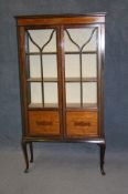 An Edwardian mahogany inlaid china cabinet with glazed door, supported on slender cabriole legs.91